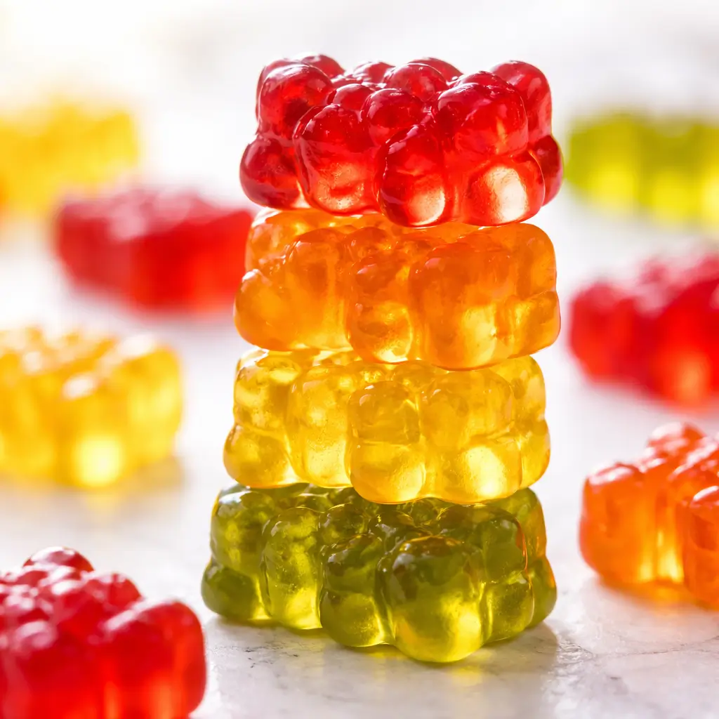 Stacked colorful homemade gummy bears with glossy texture close up